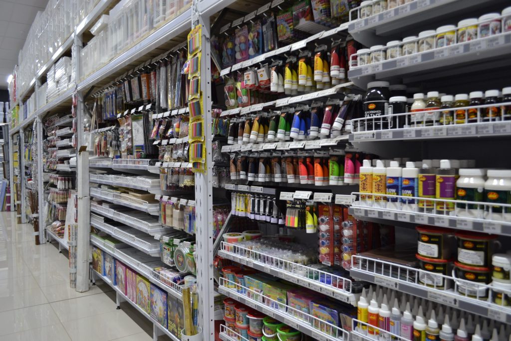 Organised retail shelving with a variety of stationery on supermarket shelves