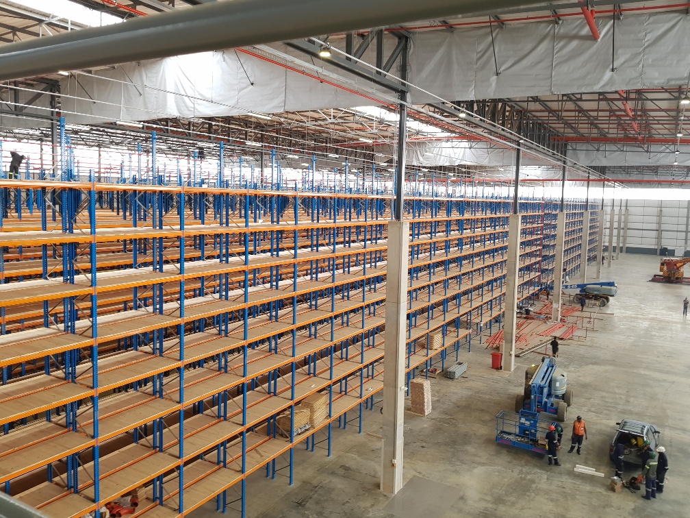 Extensive warehouse shelving systems being installed, highlighting potential warehouse shelving costs