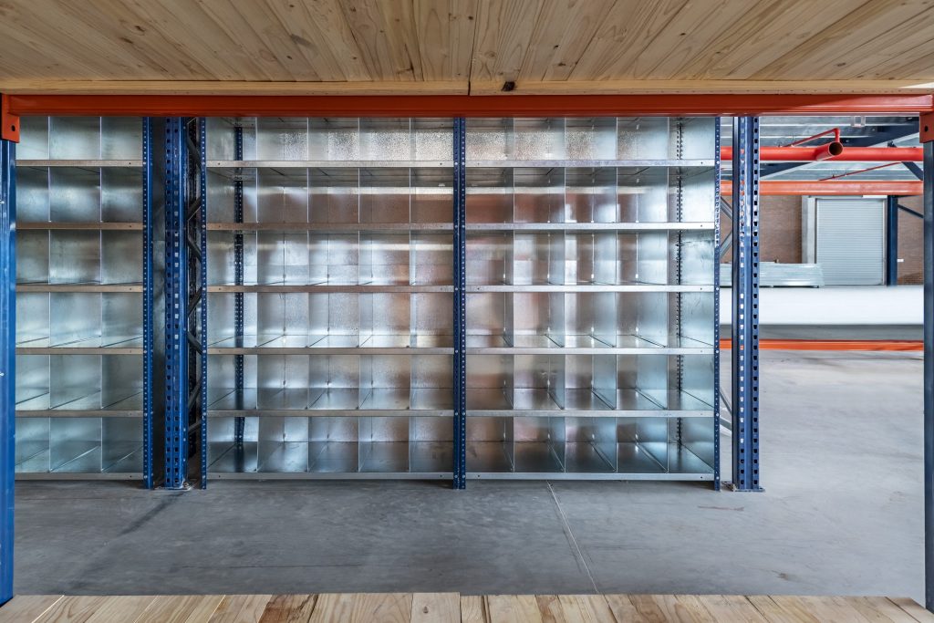 Spacious industrial warehouse with bolted metal shelving units and wood clad ceiling