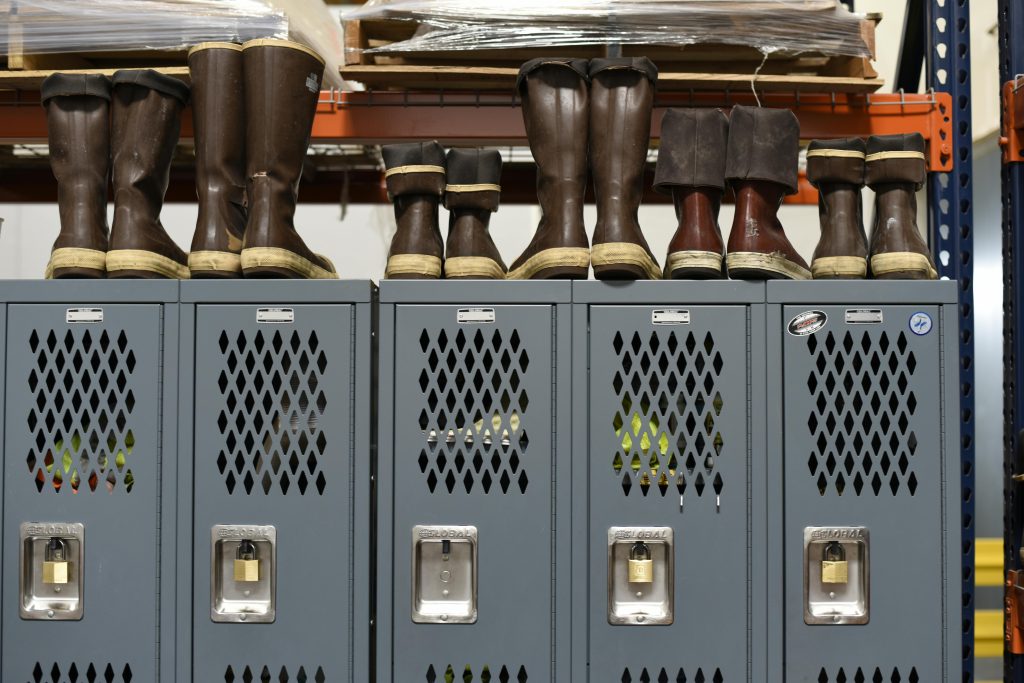 Industrial storage shelving with metal lockers and work boots in a warehouse setting