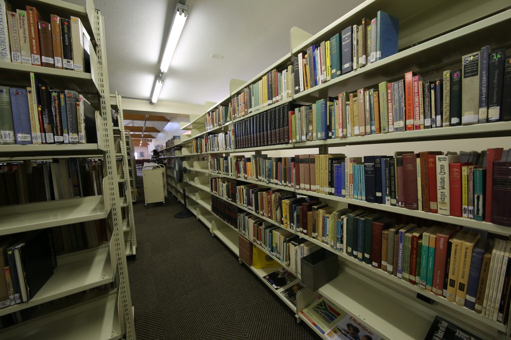 Library shelving stacked with books.
