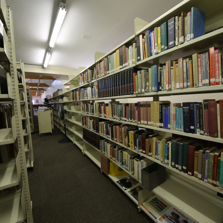 Library shelving stacked with books.
