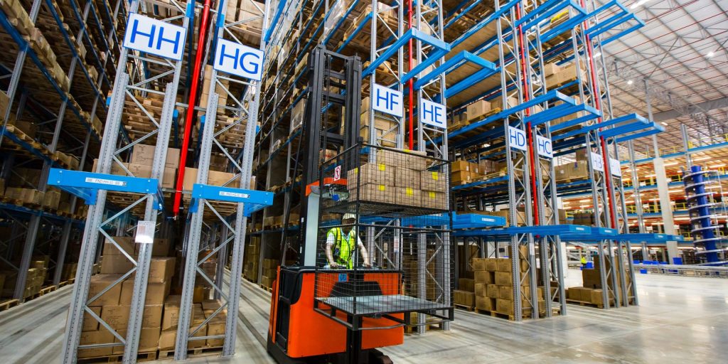 A man driving a warehouse cart stacking VNA racking and Drive-in racking