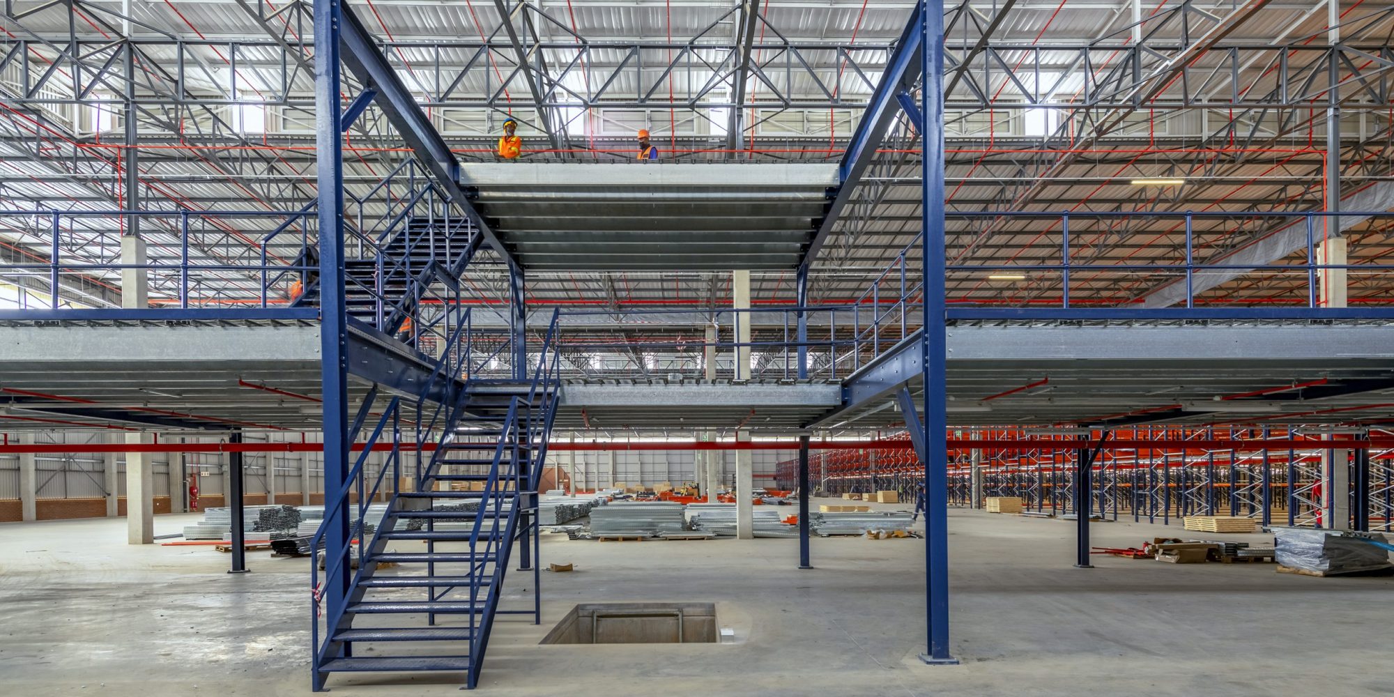RGP0940-HDRx-scaled-2000×1000 People on a structural mezzanine floor installation in a warehouse. Looking for structural mezzanine prices