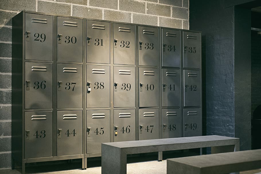 Row of steel lockers prices numbered 29 to 49 in a dimly lit room, providing secure storage solutions for businesses or facilities.
