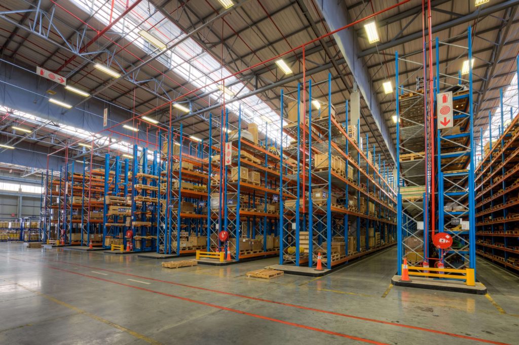 Blue racking structure erected in a large and empty well-lit warehouse as an example for light to heavy duty racking prices