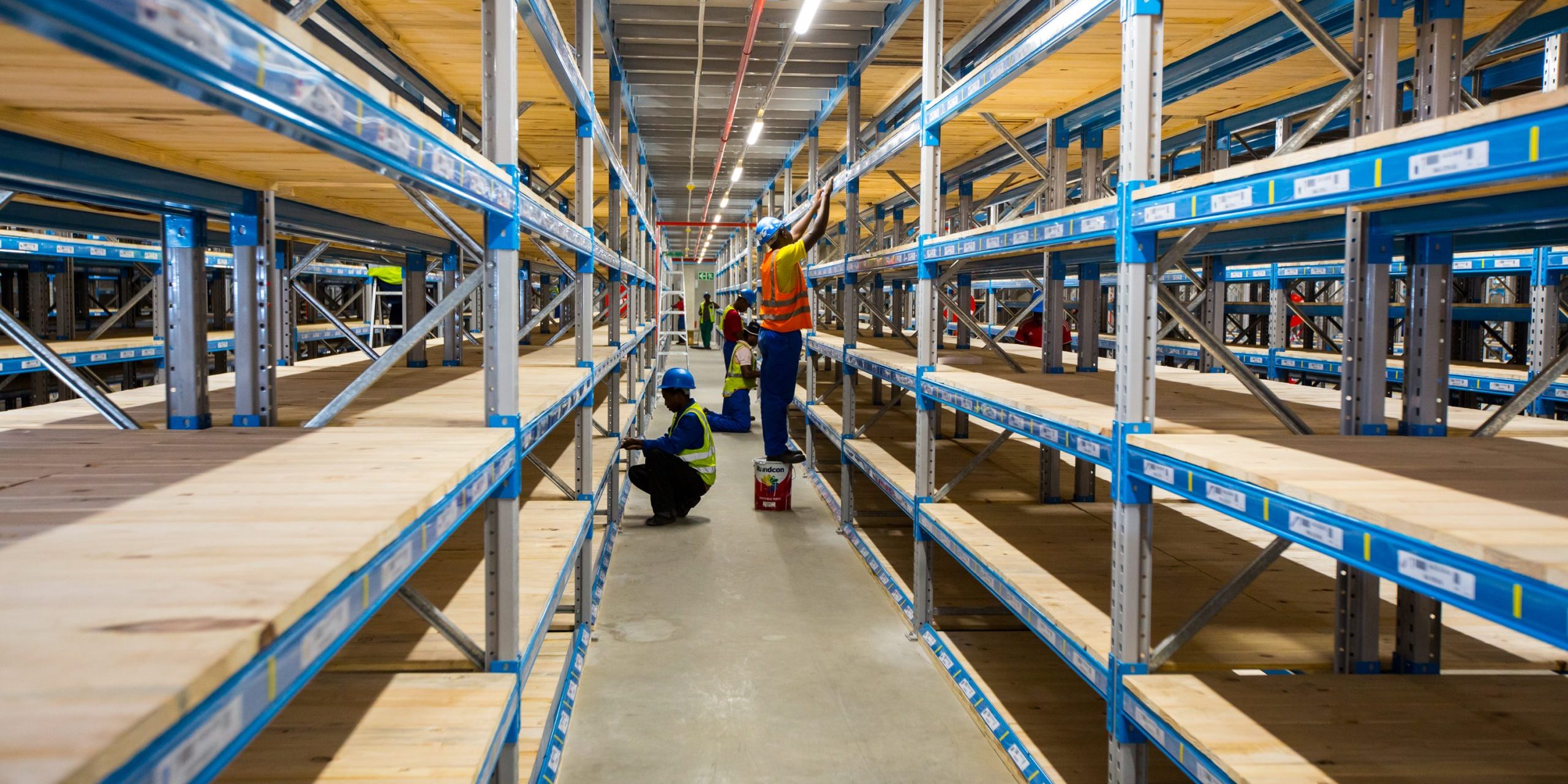 Krost-125 (1) Workers installing pick face racking systems in a large warehouse.