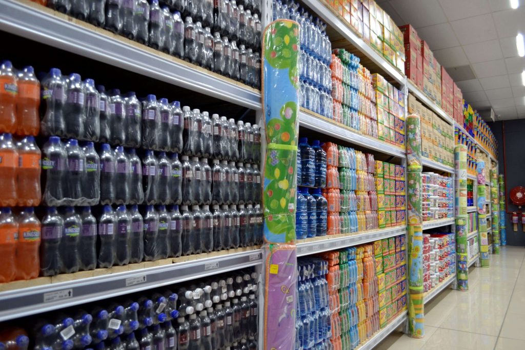 Long row of selective racking shelves stacked with various packs of bottled cooldrinks