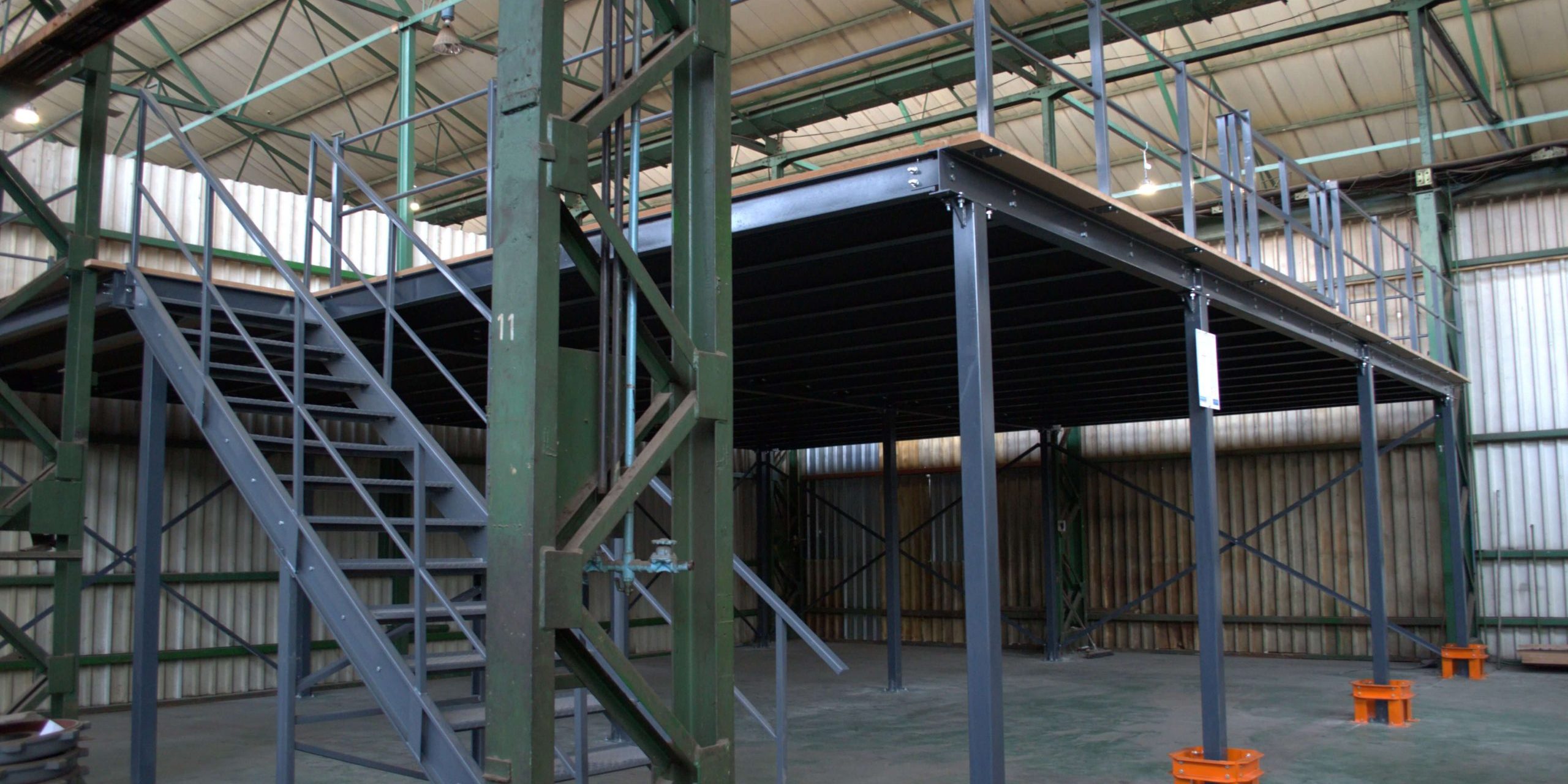 _DSC5422 Grey structural mezzanine floor on orange stands in a large and empty warehouse