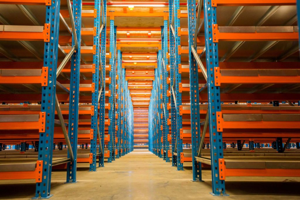 Perfectly assembled blue and orange steel rack-supported mezzanine floor in an empty warehouse
