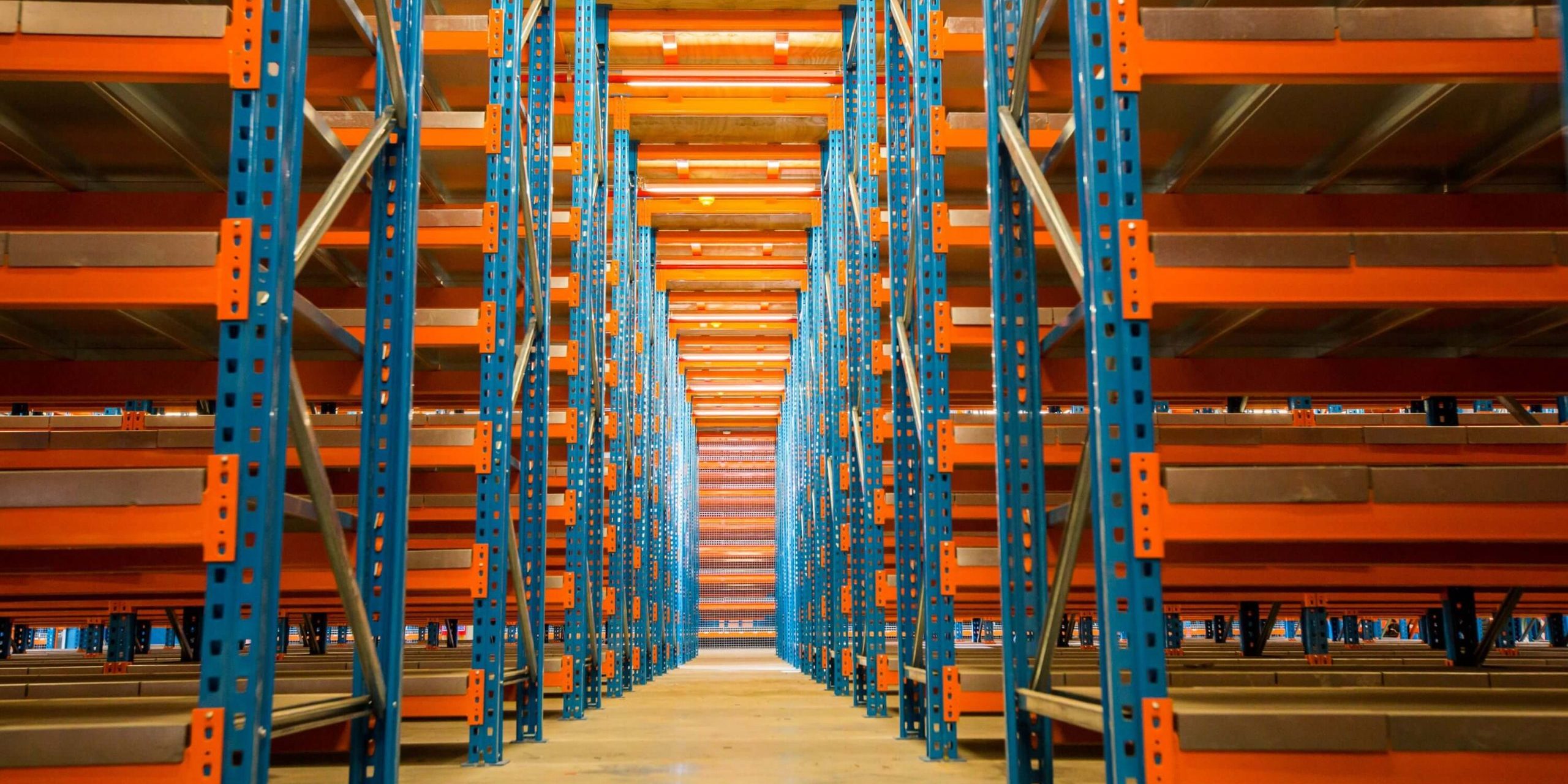 Krost-14 Perfectly assembled blue and orange steel rack-supported mezzanine floor in an empty warehouse