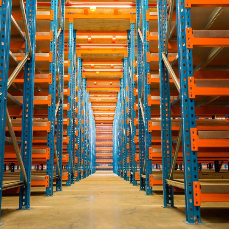Perfectly assembled blue and orange steel rack-supported mezzanine floor in an empty warehouse