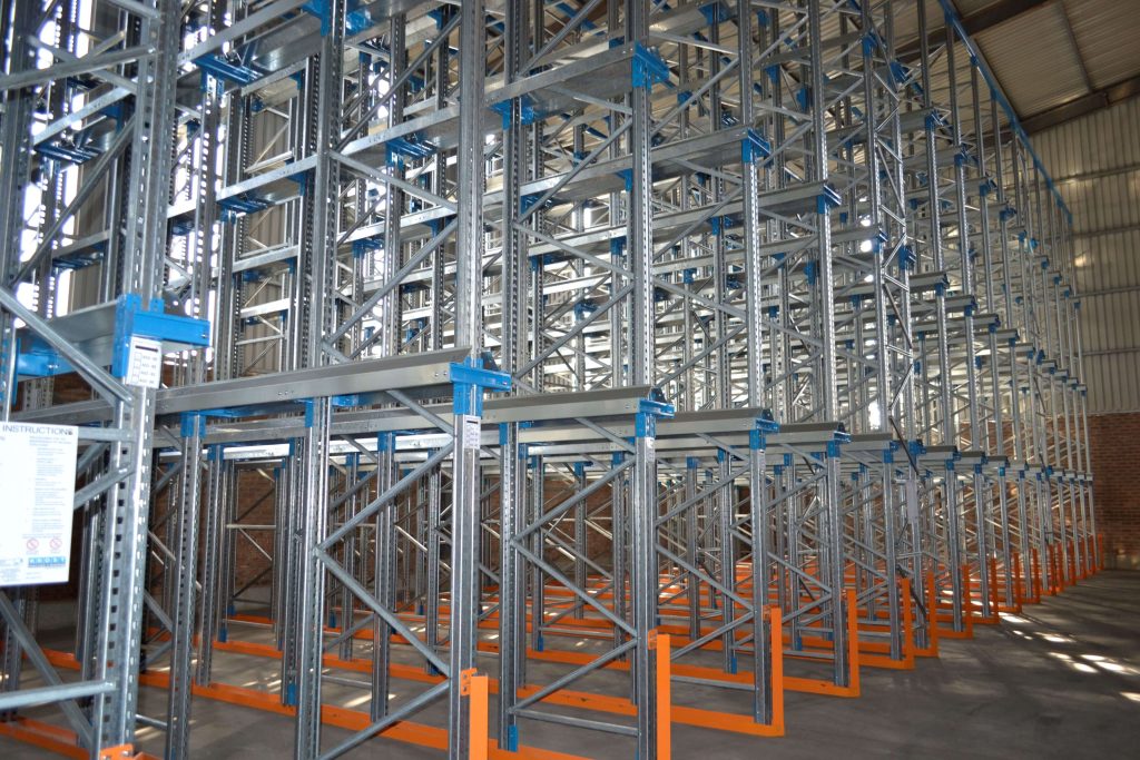 Side view of a multi levelled steel drive-in racking system in a warehouse