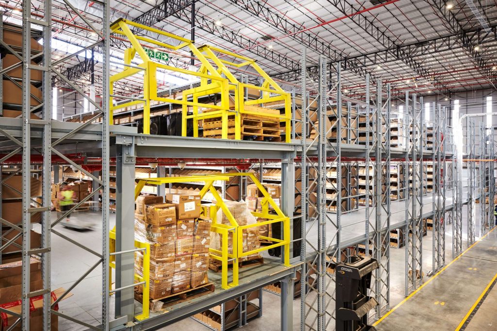 A multi-levelled structural mezzanine floor system with safety pallet gates stacked with boxes
