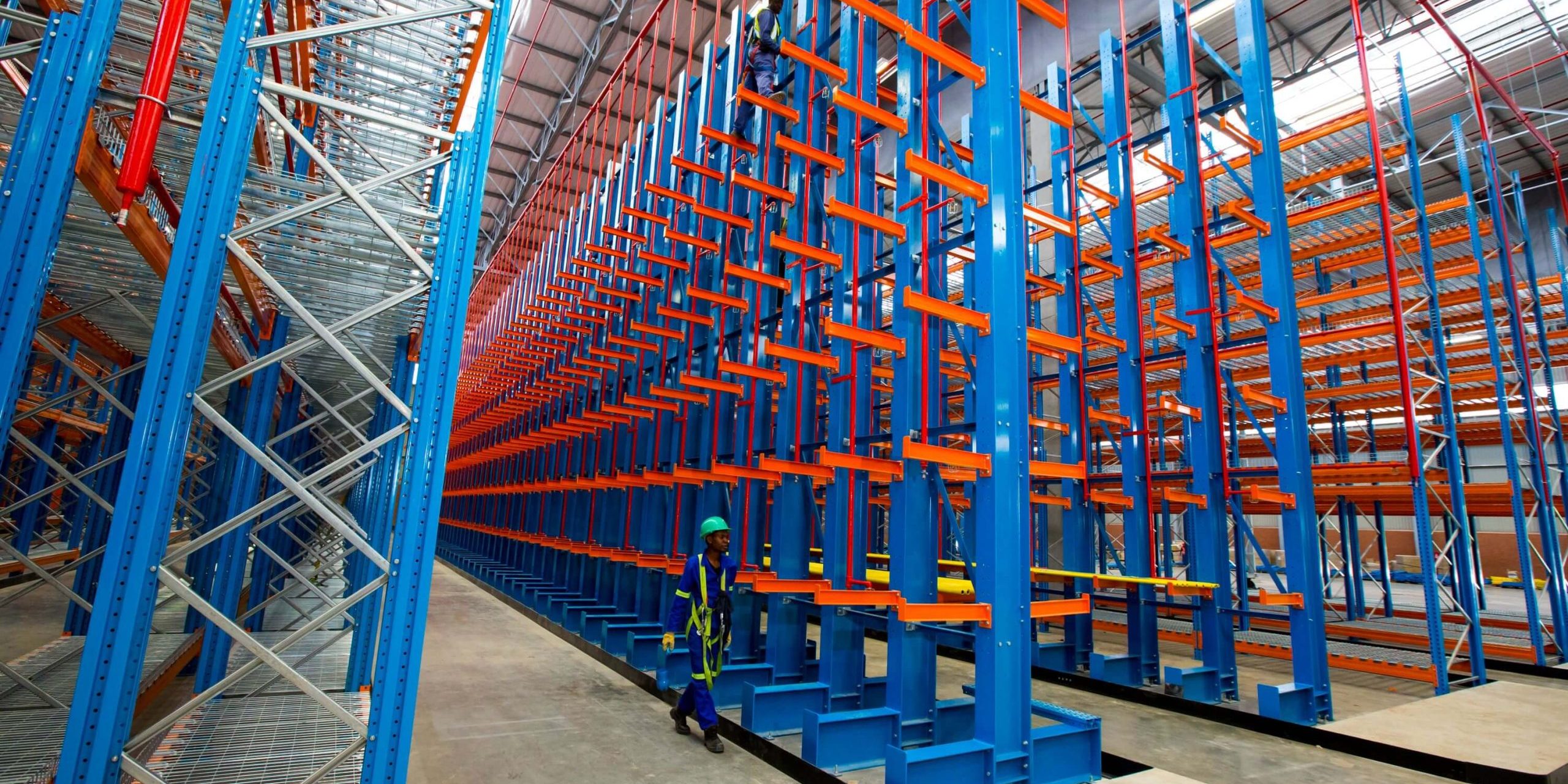 Krost-41 Worker in blue overalls walking beside an empty 6 level cantilever racking structure
