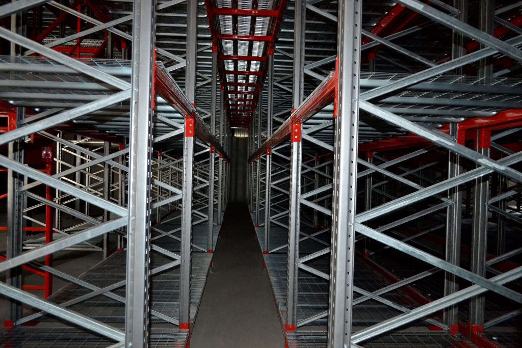 Close up of the aisle of a multi-level pick face racking system in a dim warehouse