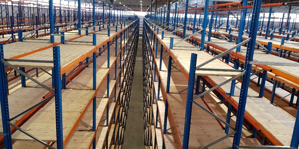 20191112_072544_resized A wide view of a spacious warehouse filled with high metal shelving units, organized for efficient storage and inventory management.