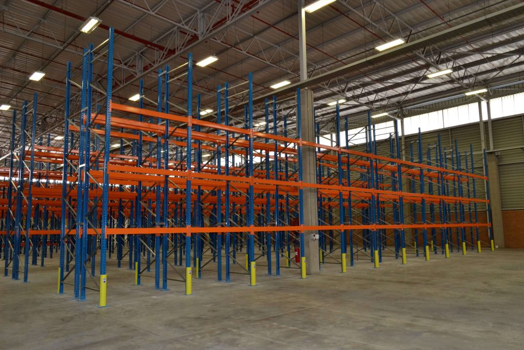 A newly installed multi-level pallet shuttle racking system in a large empty warehouse