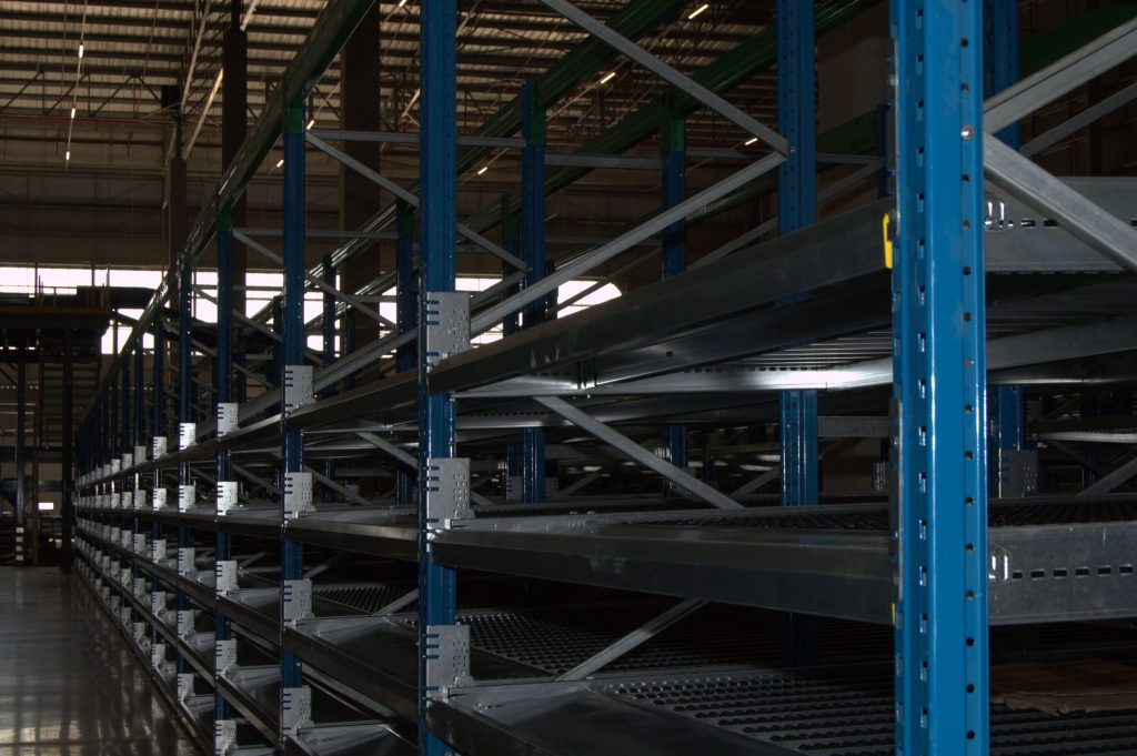 Neatly installed empty blue steel flow racking system in a warehouse environment
