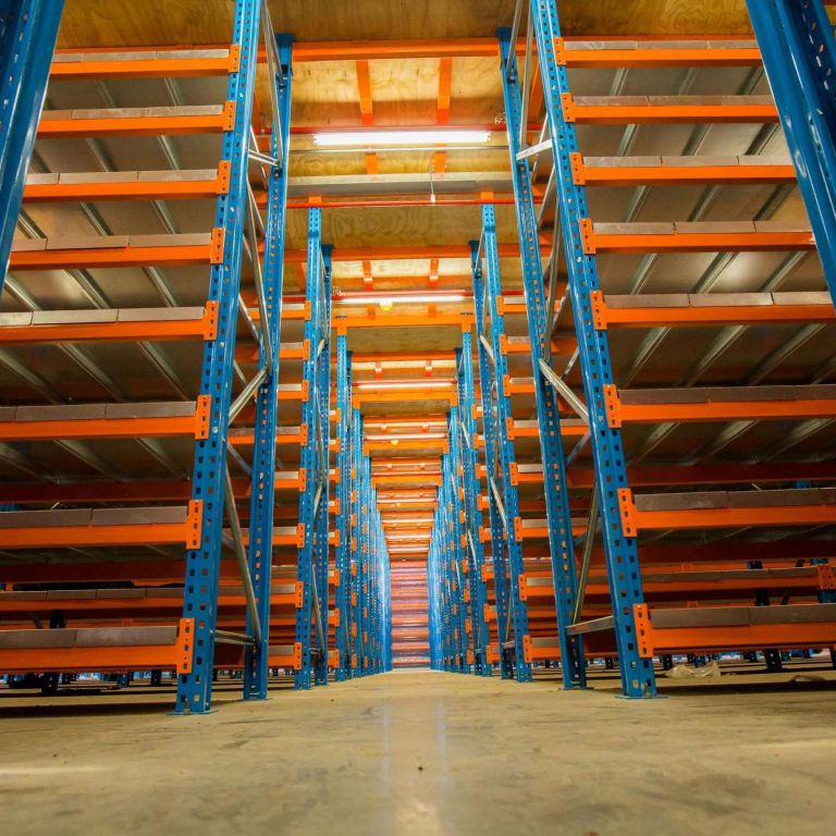 Rack supported mezzanine floors with blue and orange framework in a warehouse setting