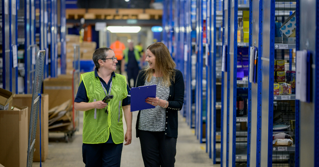 Two female staff assessing a warehouse to implement a top manual picking system