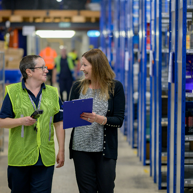 Two female staff assessing a warehouse to implement a top manual picking system