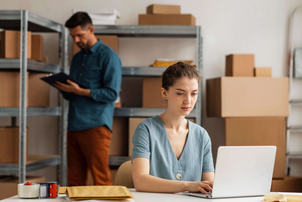 A couple conducting stock-taking in an e-commerce warehouse fitted with industrial shelves