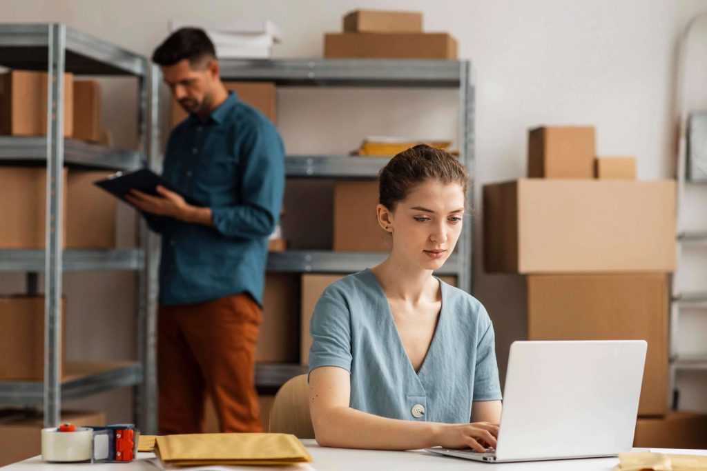 A couple conducting stock-taking in an e-commerce warehouse fitted with industrial shelves