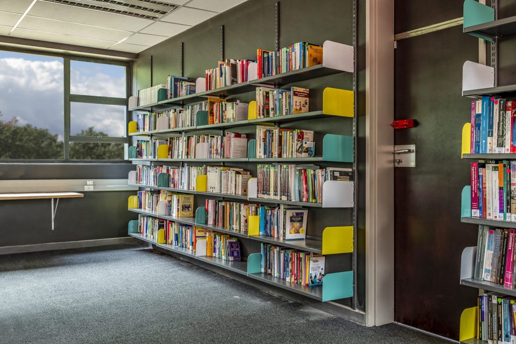Library shelves by a window with a study area