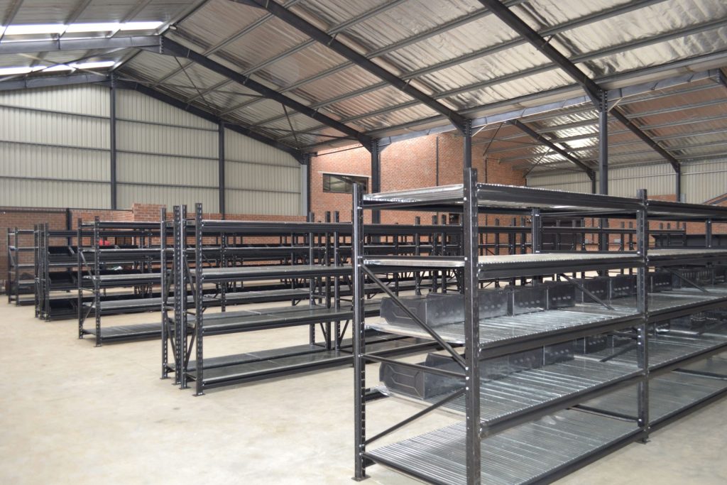 Longspan vs. Mobile Shelving: Dark longspan shelves in an empty warehouse setting.