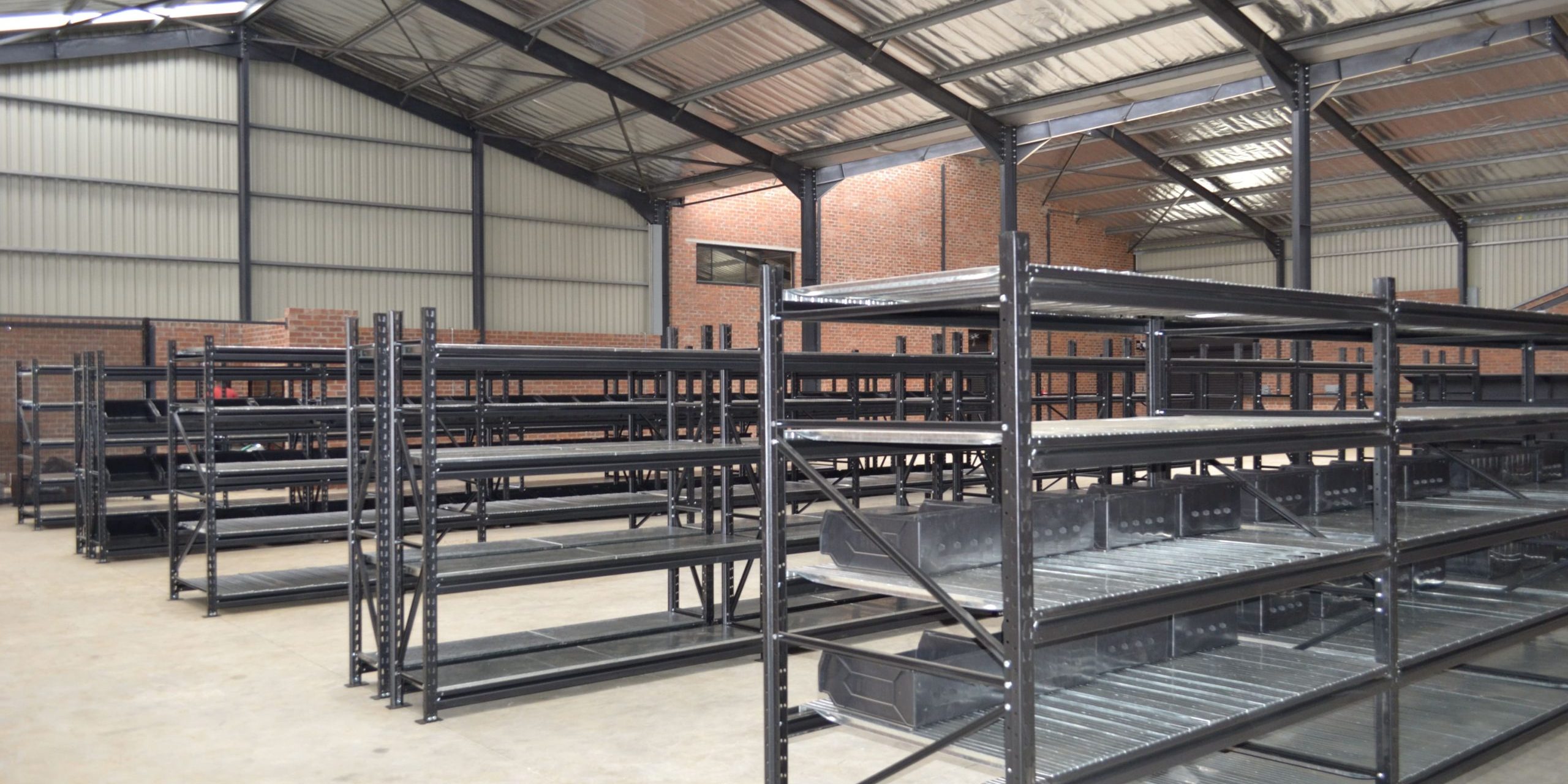 _DSC7249 (1) Longspan vs. Mobile Shelving: Dark longspan shelves in an empty warehouse setting.