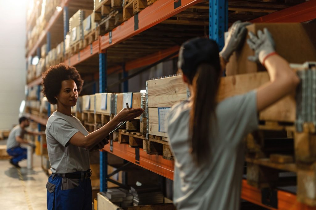 An African worker and her female colleague managing warehouse process flow.
