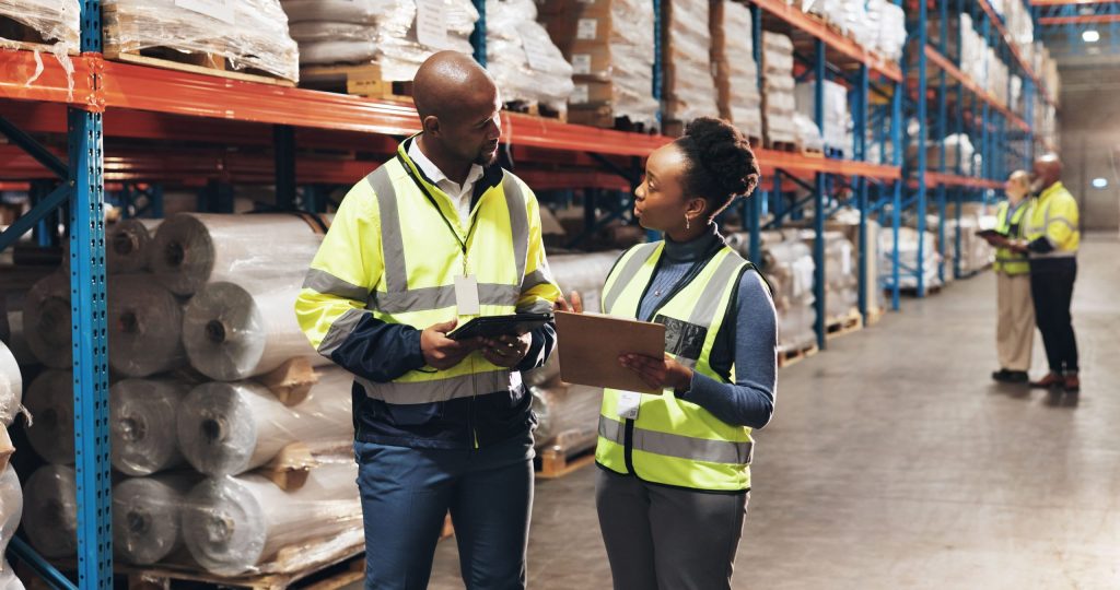 Several workers taking stock in a large central distribution warehouse