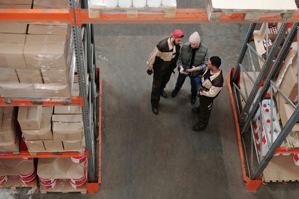 Pallet shuttle vs. long-span racking: Workers standing and talking near some racking in a warehouse
