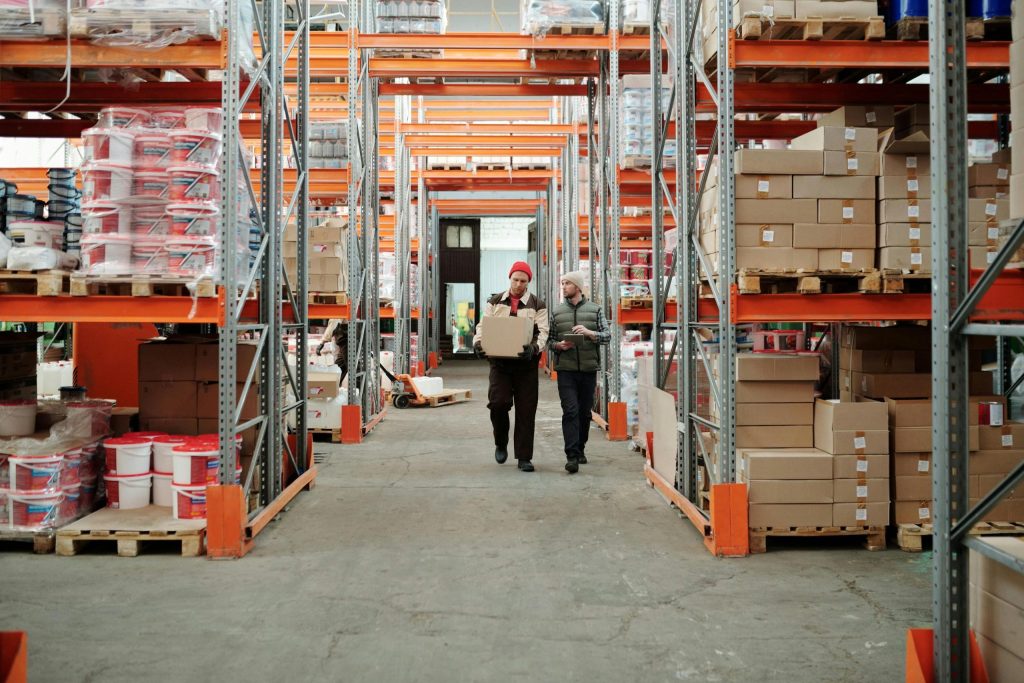 Selective pallet vs. push-back racking: Workers walking along an aisle of pallet racks in a warehouse