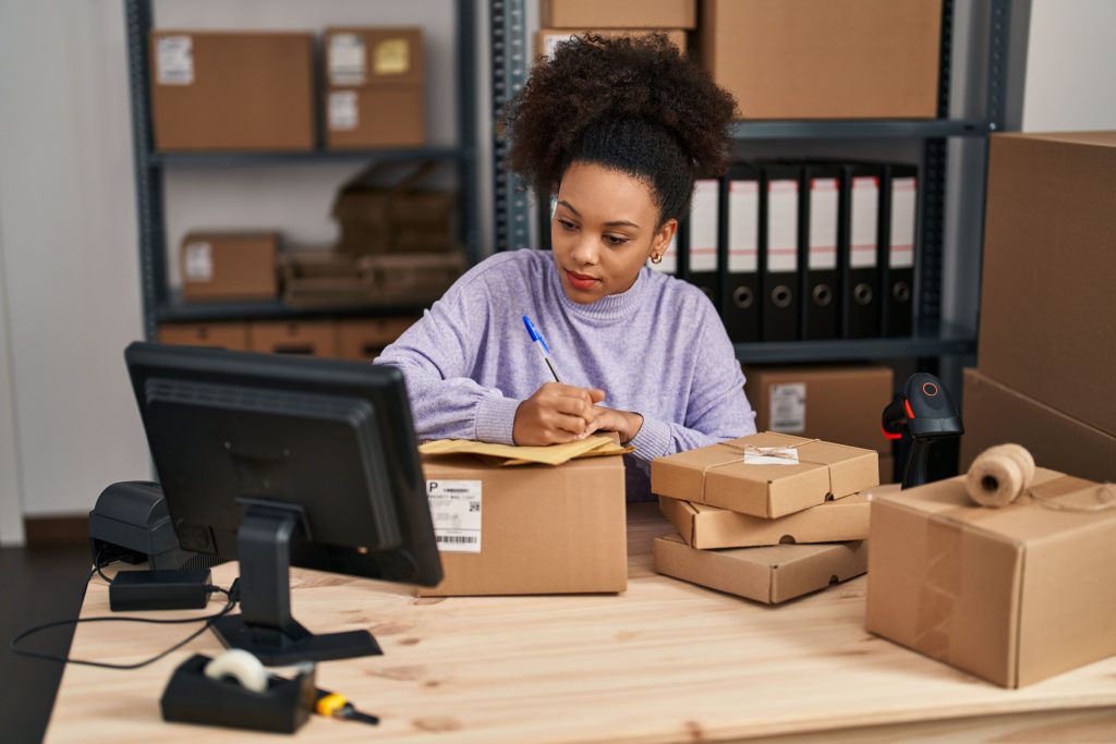 A young online business owner in a distribution centre, fulfilling an online order with goods store on industrial racking