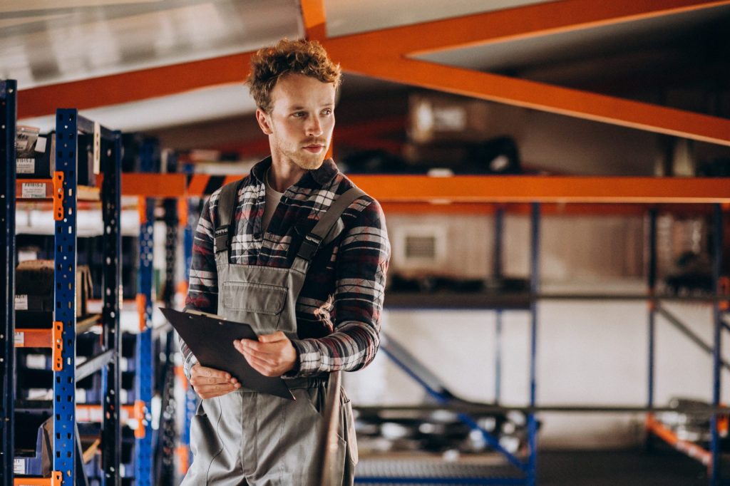warehouse worker with a clipboard comparing catwalk racking vs. bolted shelving