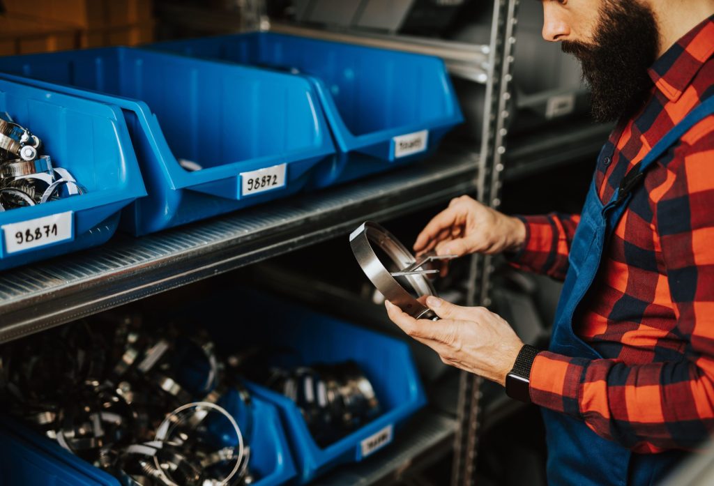 Adult man working in car and truck spare parts warehouse