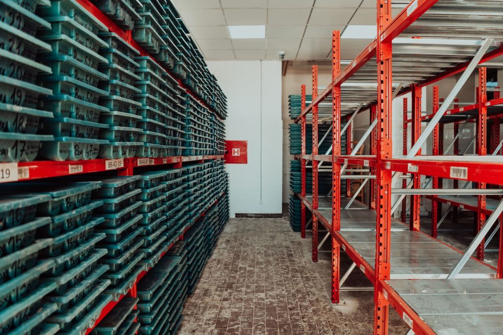 A free-standing metal shelving unit in a small garage stocked with tools