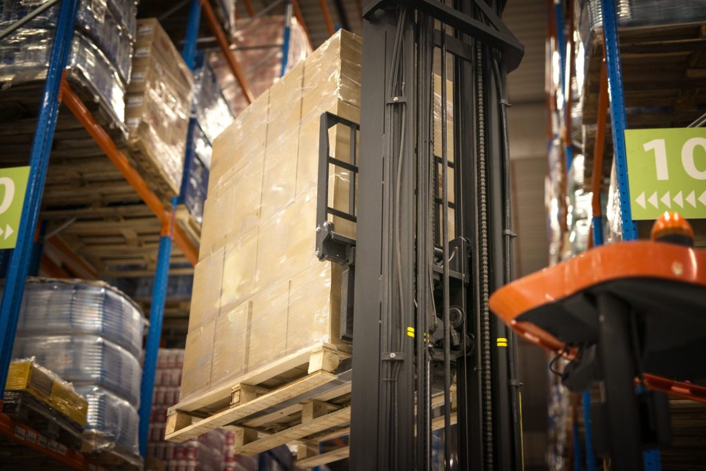 A forklift in operation in a warehouse to show mobile shelving and pallet shuttle racking differences.