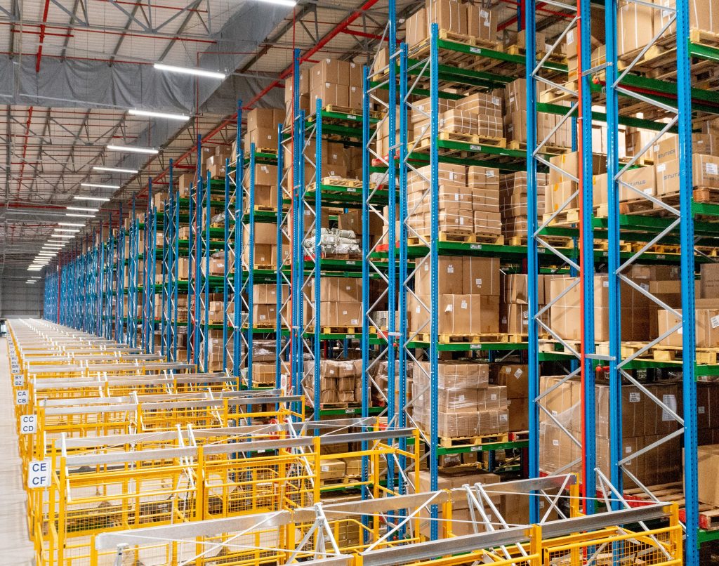 A large, densely stacked VNA rack in a warehouse showing how rivet shelving and VNA racking compare.