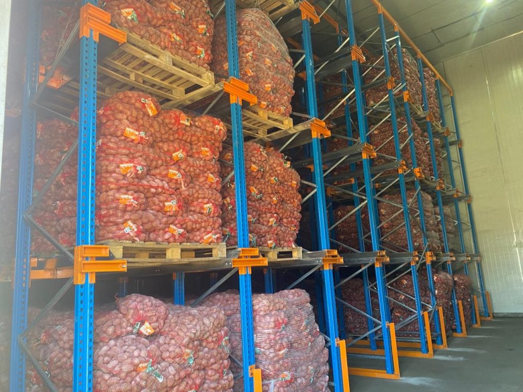 A large set of the best warehouse racking storing potatoes in a warehouse.
