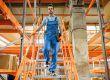 A warehouse worker walking down the stairs of a structural mezzanine floor design structure in a retail warehouse