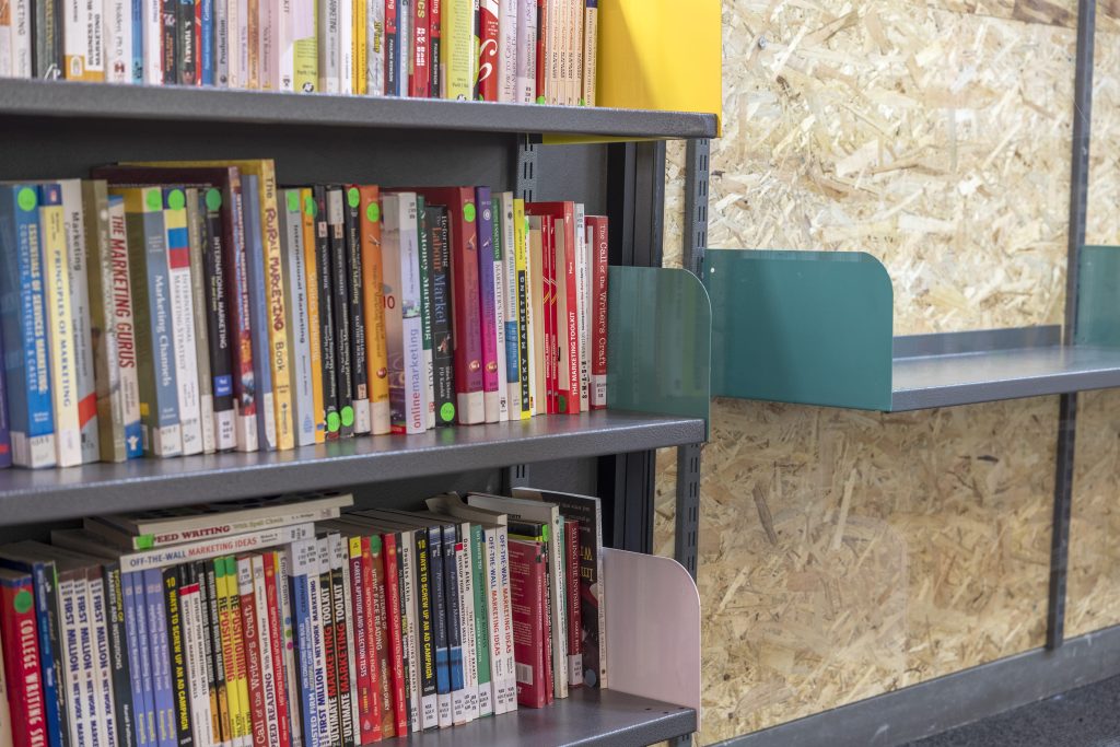 Installed library shelves stocked with books to compare cantilever racking vs. library shelving
