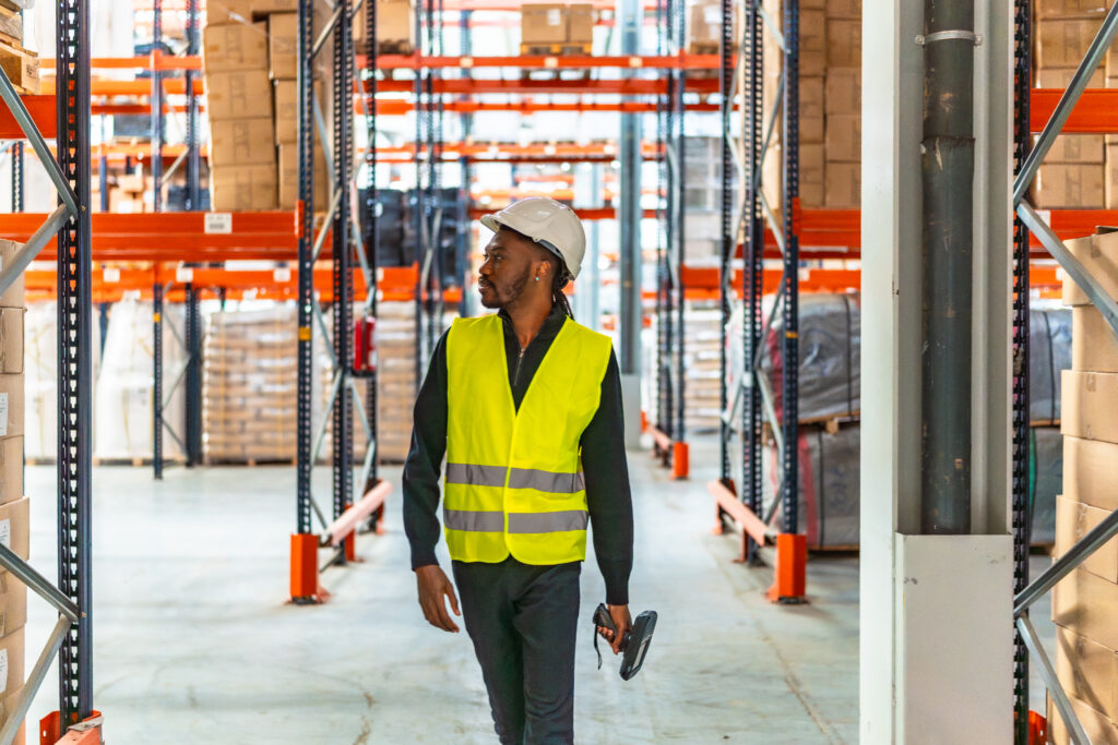 Warehouse worker scanning stock in a high density racking aisle